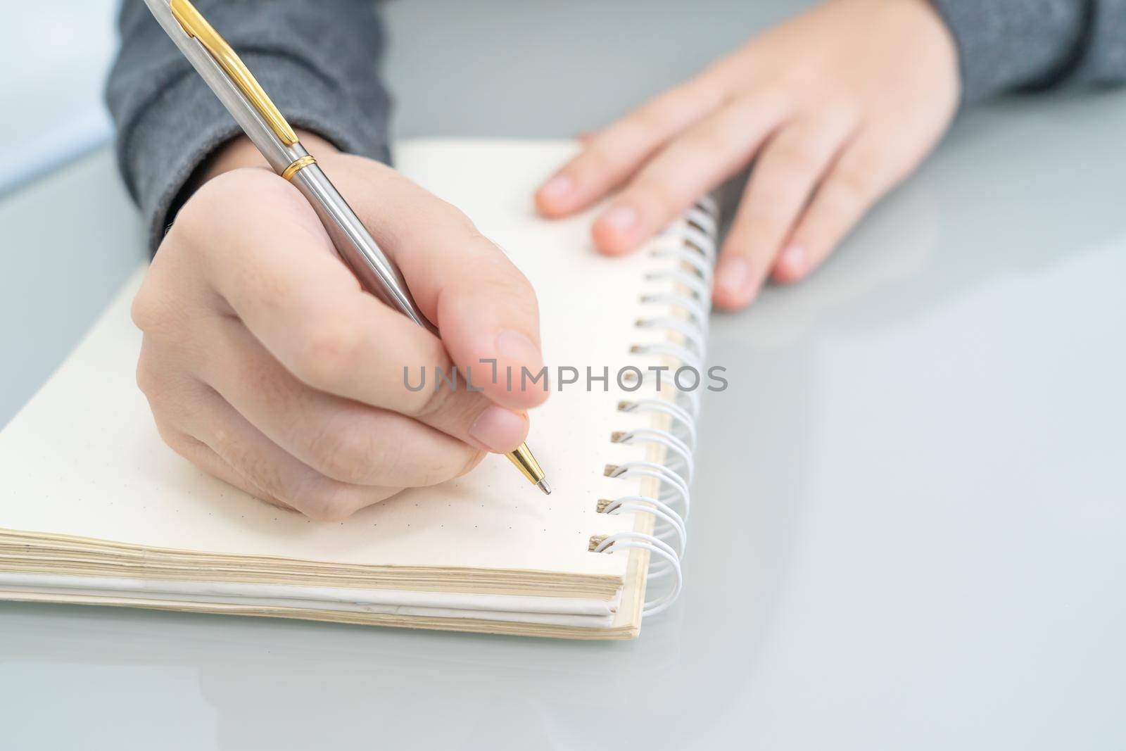Hands working writing notebook on desk  by stoonn