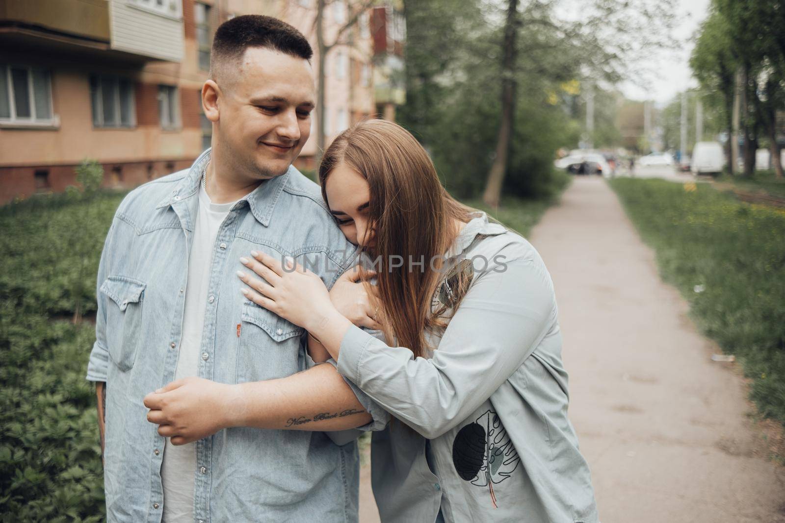 a couple in love walks around the city. the girl lay on the guy's arm by Symonenko