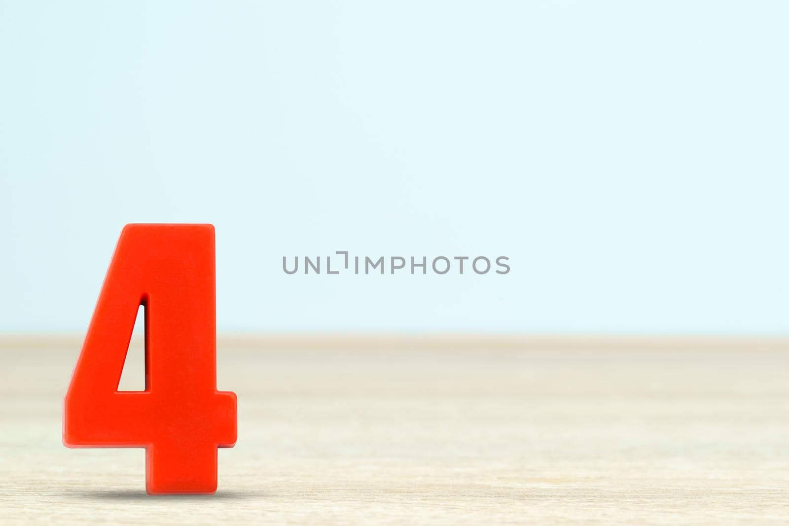Shot of a number four made of red plastic on table with copy space