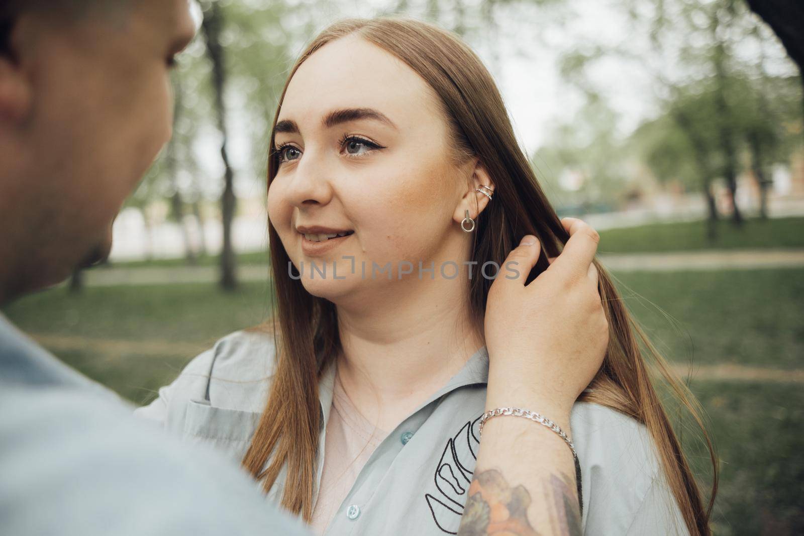 a guy admires his girlfriend and adjusts her hair. look on girl by Symonenko