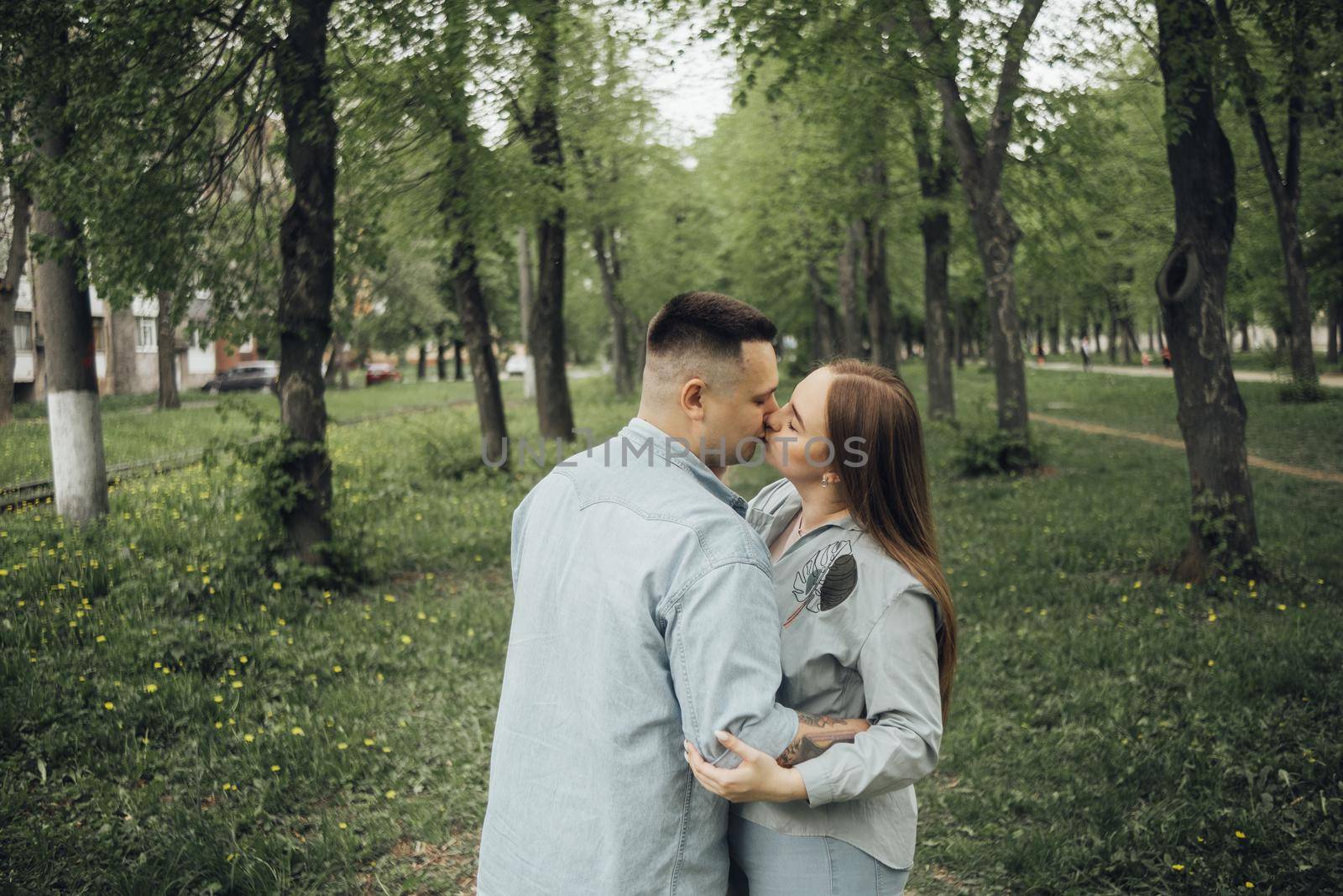 a couple kissing standing in the woods by Symonenko