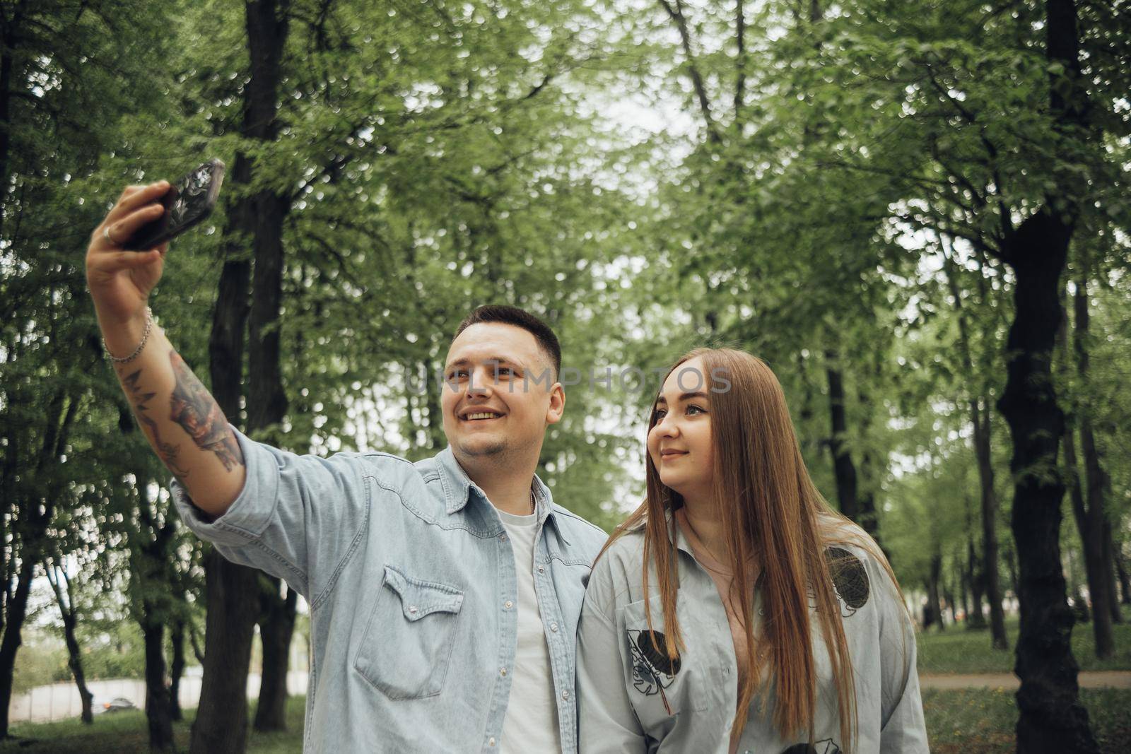 a couple in love in the park takes a joyful selfie by Symonenko