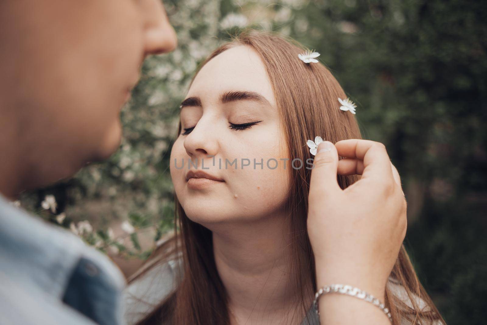 a guy arranges flowers in the hair of his beloved by Symonenko