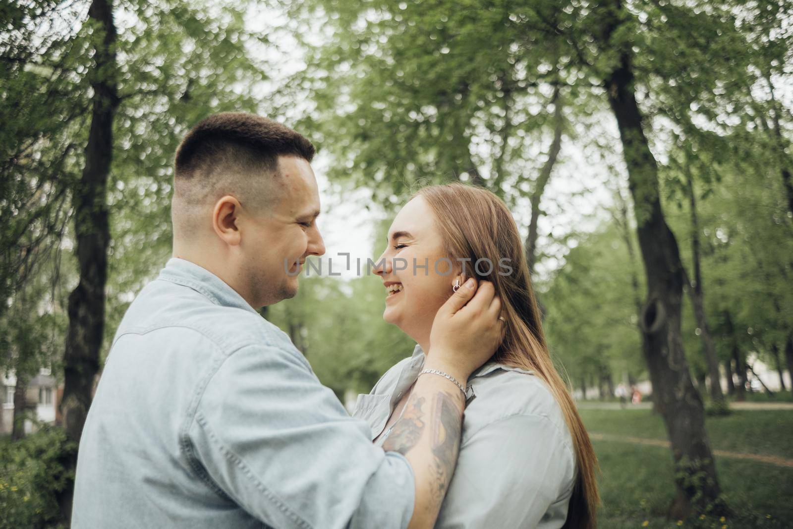 a couple in love in the park admires each other, laughs by Symonenko