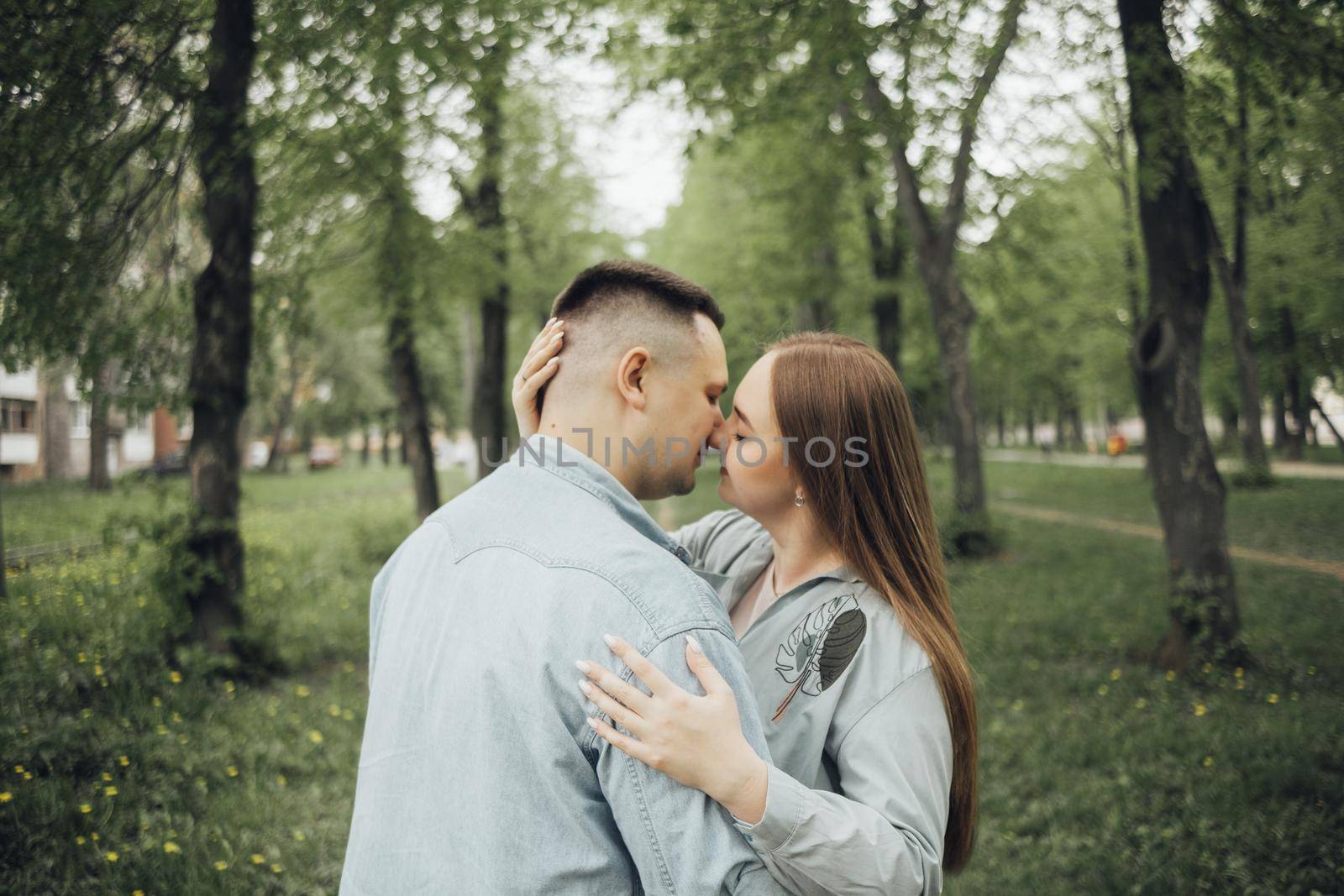 a couple kissing standing in the woods by Symonenko