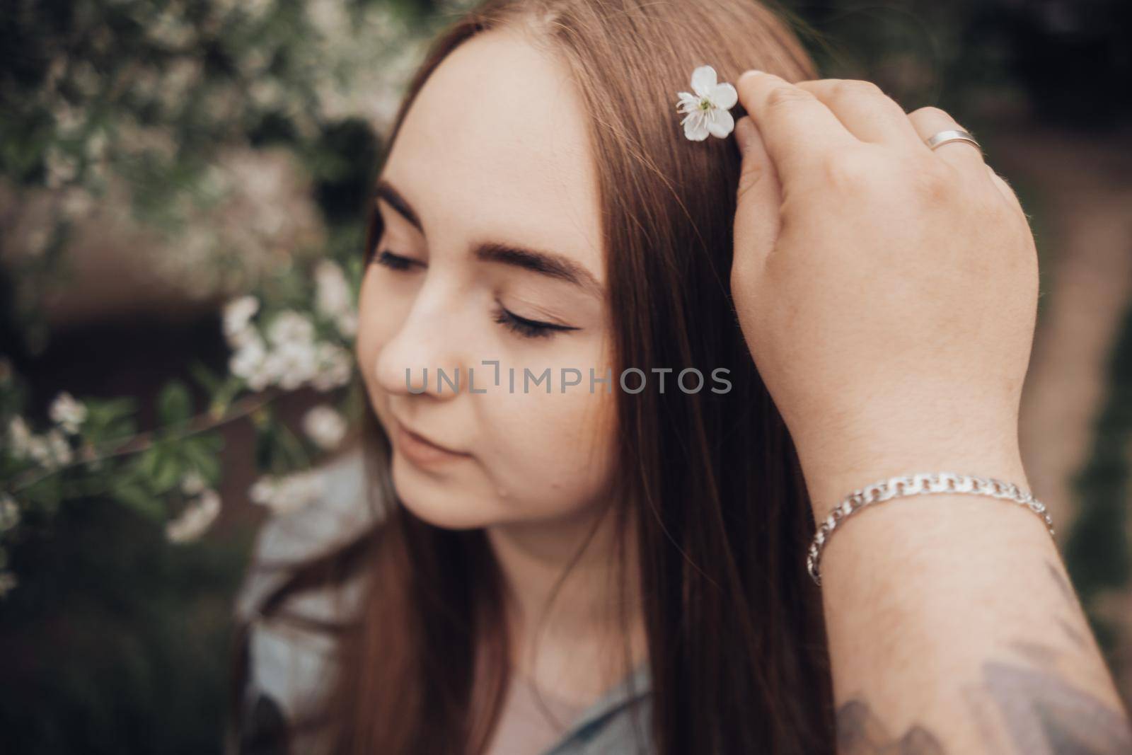 a guy arranges flowers in the hair of his beloved by Symonenko