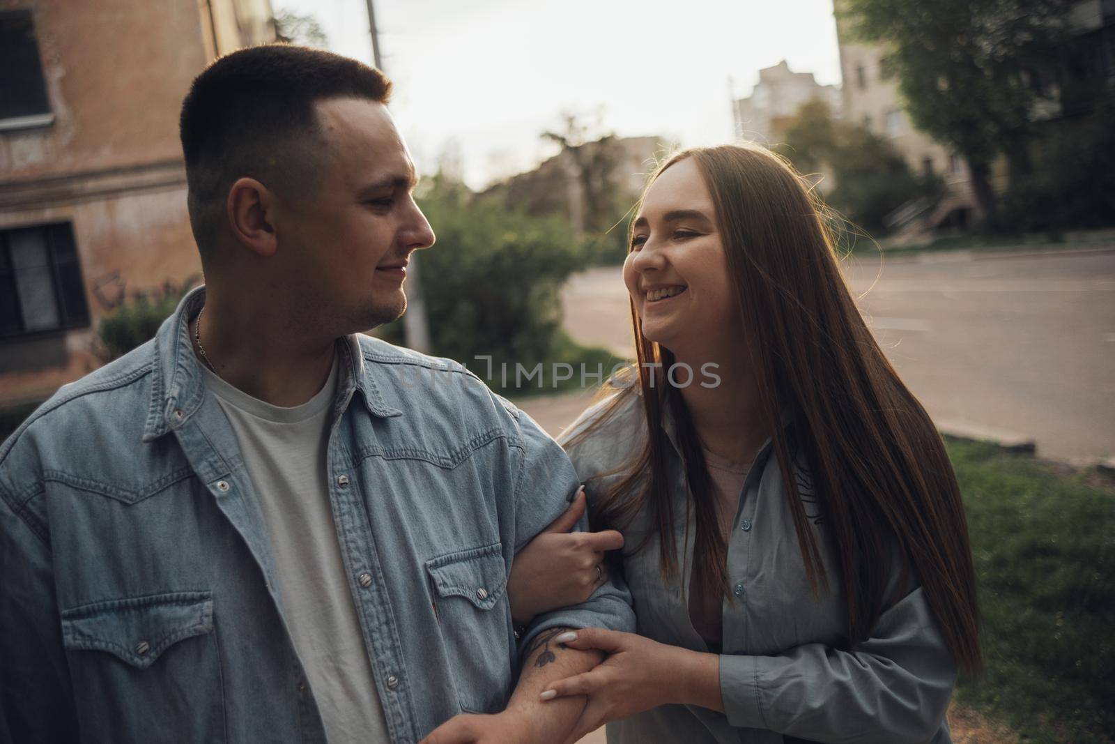 couple in love merrily walking the city at sunset by Symonenko