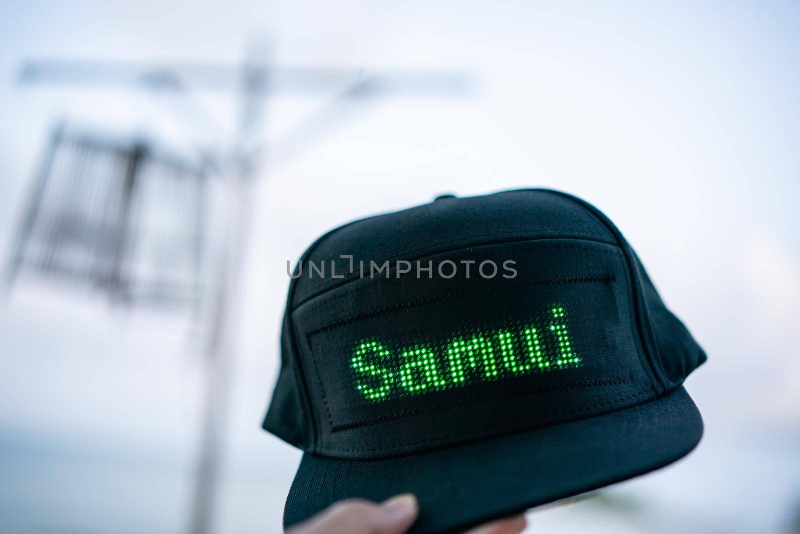 Hand holding black baseball cap with LED letter "Samui", summer vacation. by sirawit99