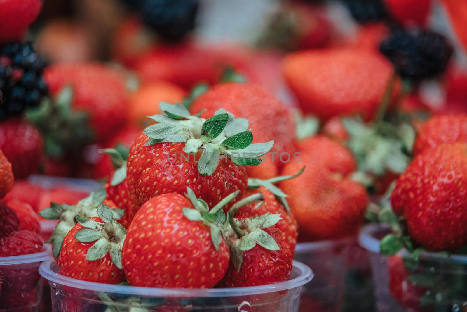 Selective focus. fresh strawberries, raspberries and blackberries in a glass. Summer Beach Food.