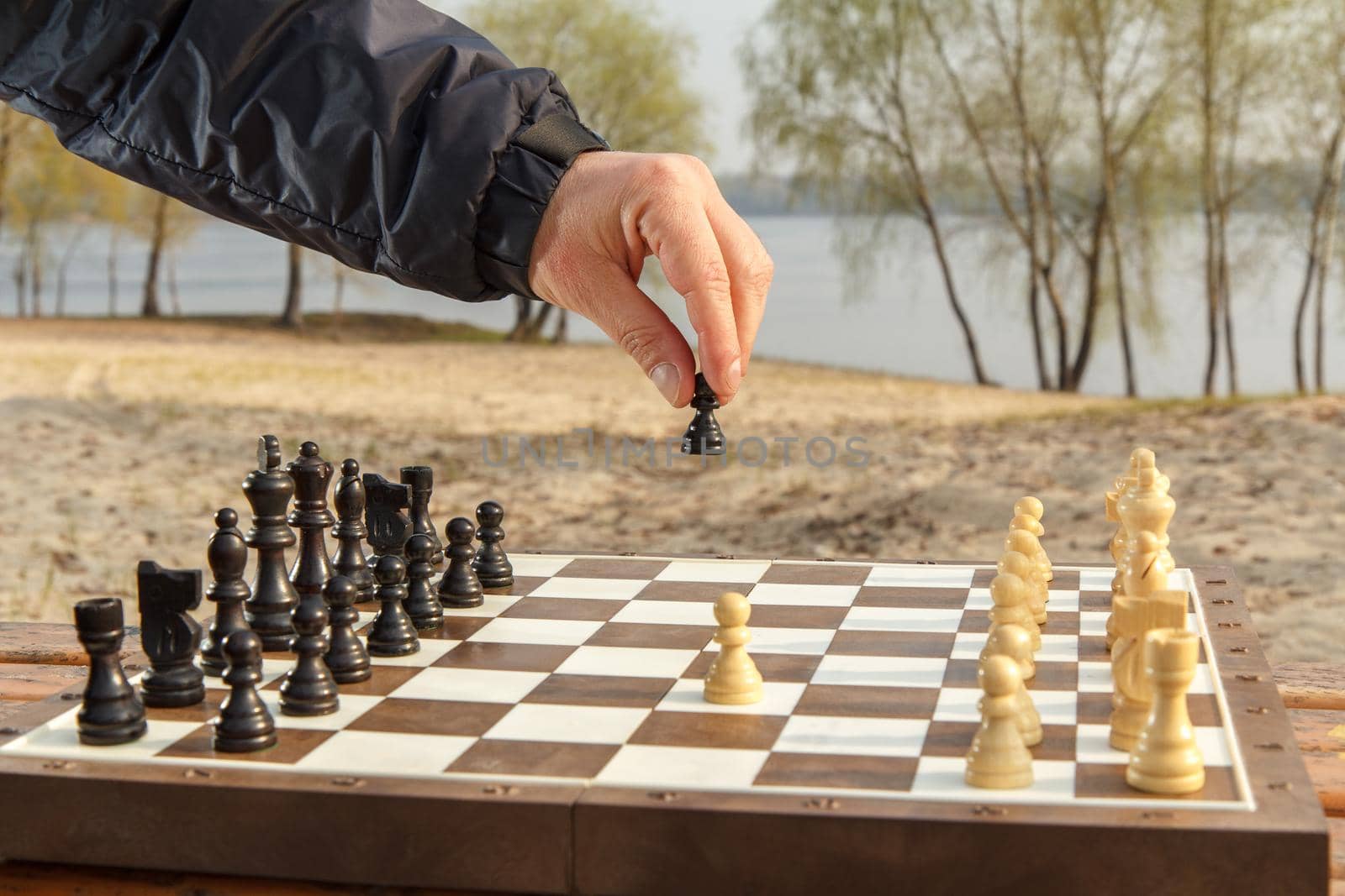 Male hand is hollding a pawn The second move in a game of chess Shallow depth of field focusing on players hand