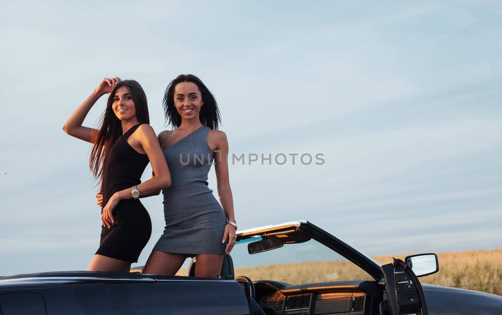 Two women in a black car on the roadside roads.