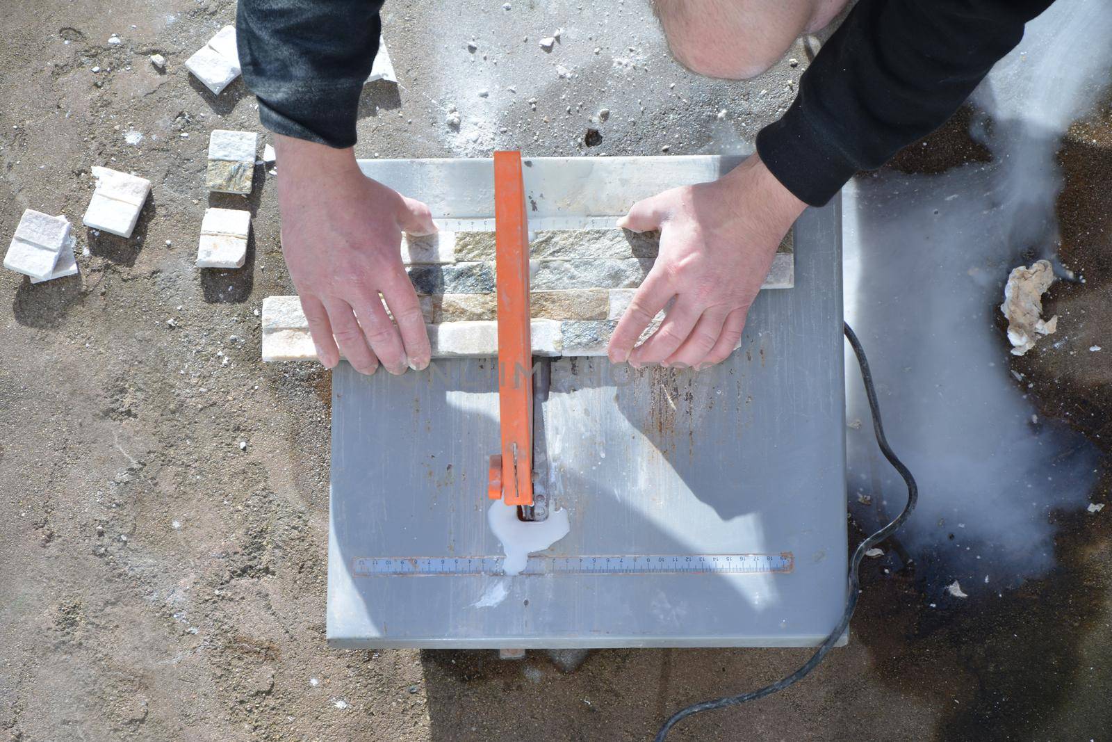 Worker using wheel tiles and stone cut