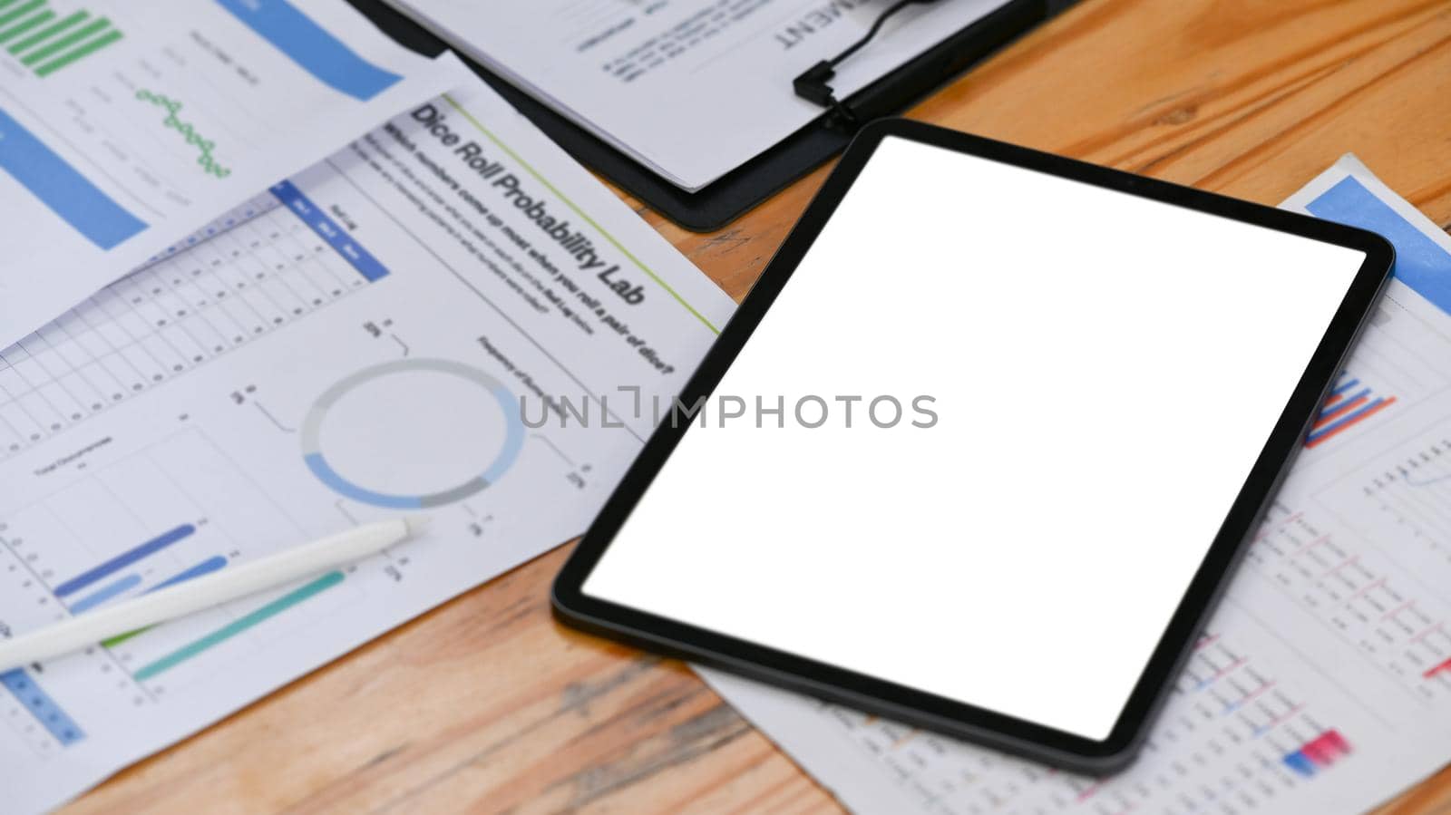 Digital tablet with blank screen and financial documents on office desk.