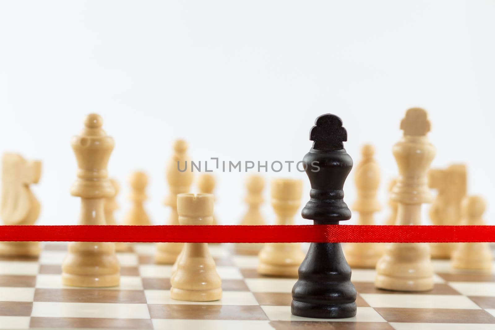 The King's figure crossing the red finish ribbon. Chess business leadership and success concept