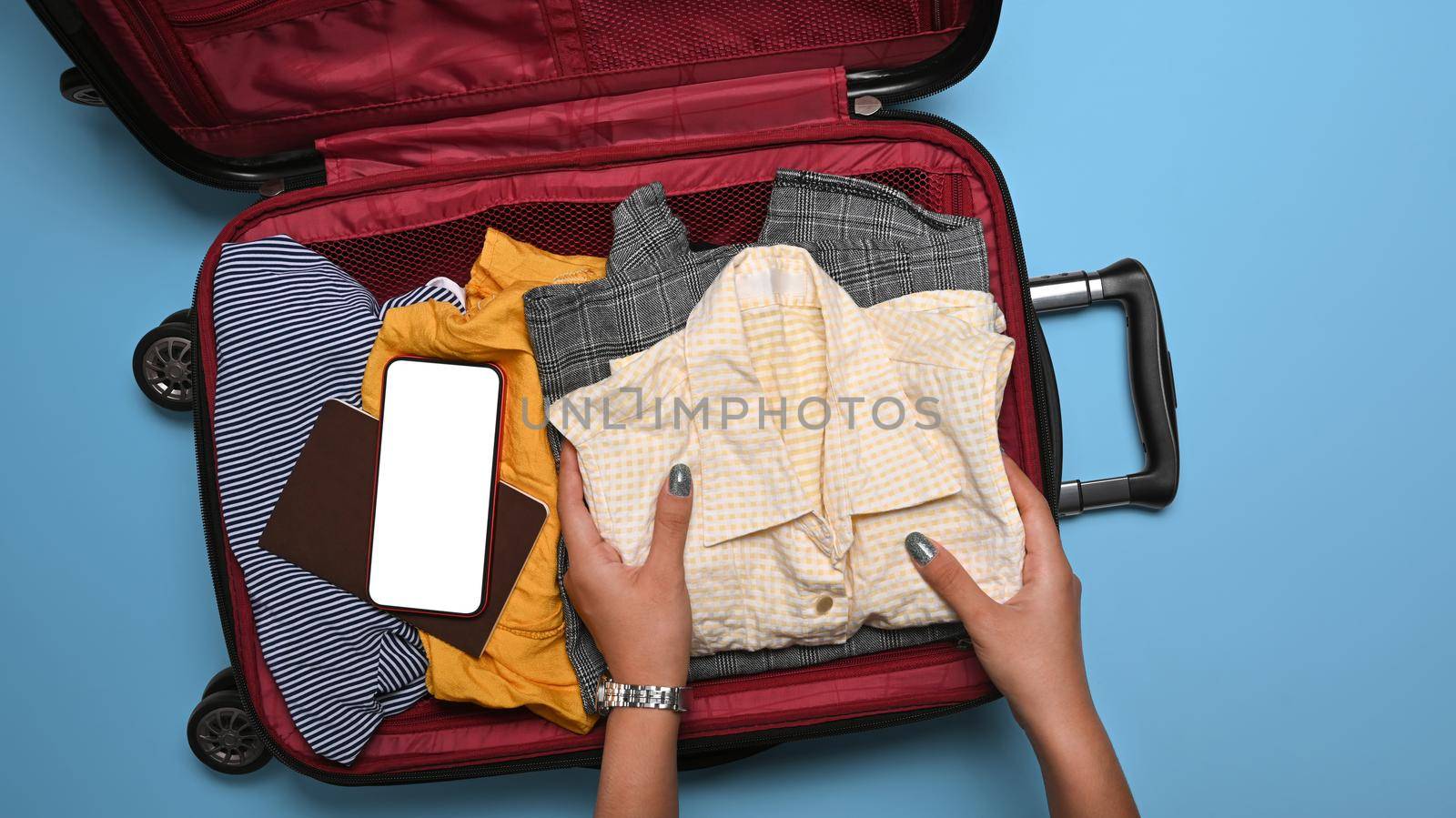 Woman packing clothes into suitcase. Preparing for the summer vacations.