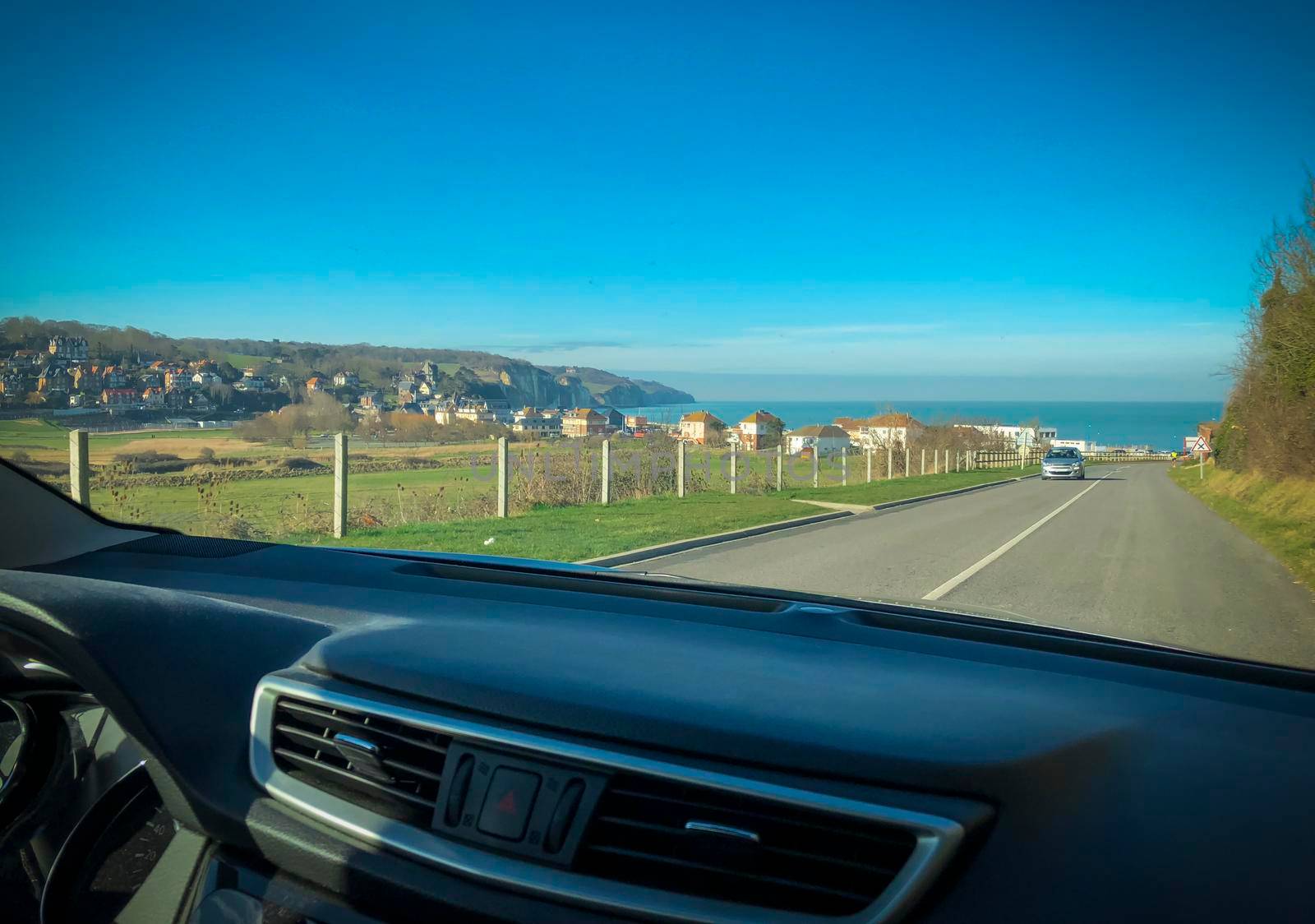 Road view through the car window on the ocean