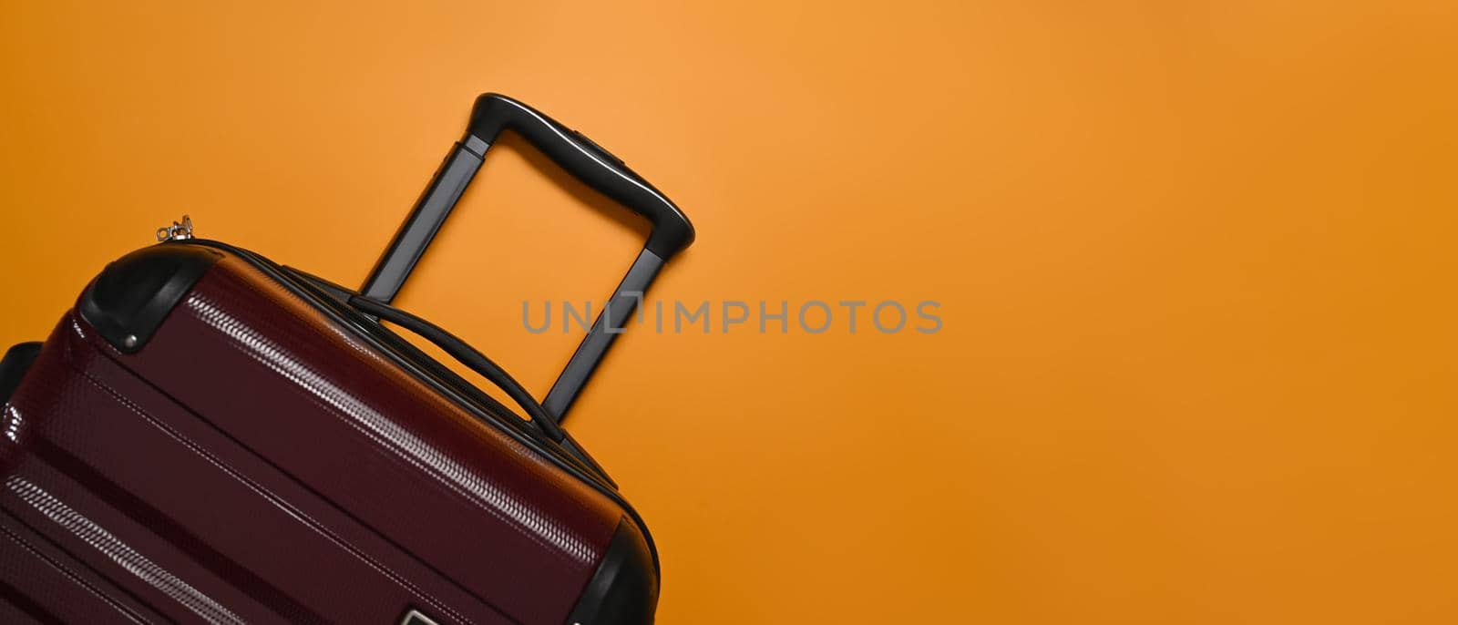 A suitcase on orange background with cop space. Preparing for the summer vacations.