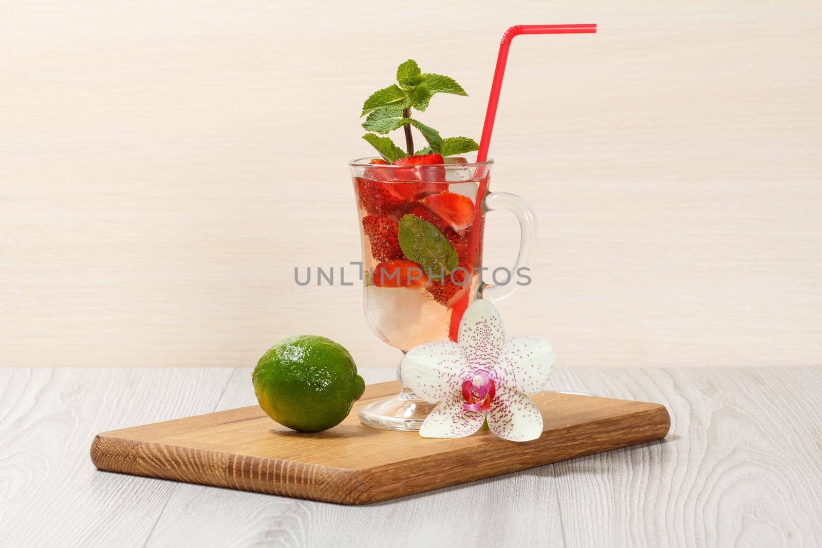 Carbonated lemonade with strawberry slices and mint on an wooden cutting board, Cold beverage for hot summer day