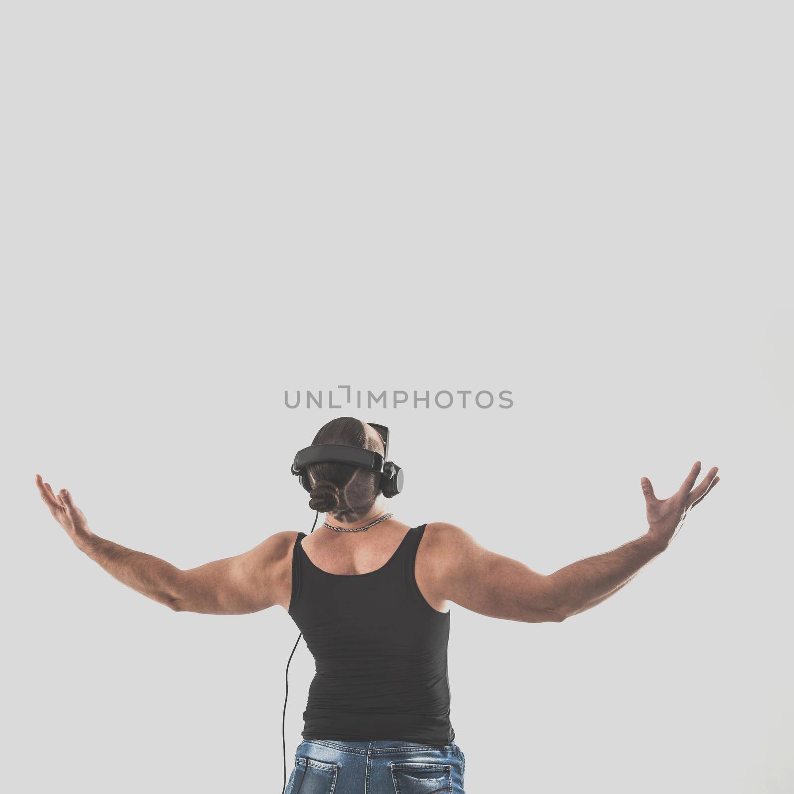 back view - emotional bodybuilder with headphones and sunglasses on a white background.the photo has a empty space for your text