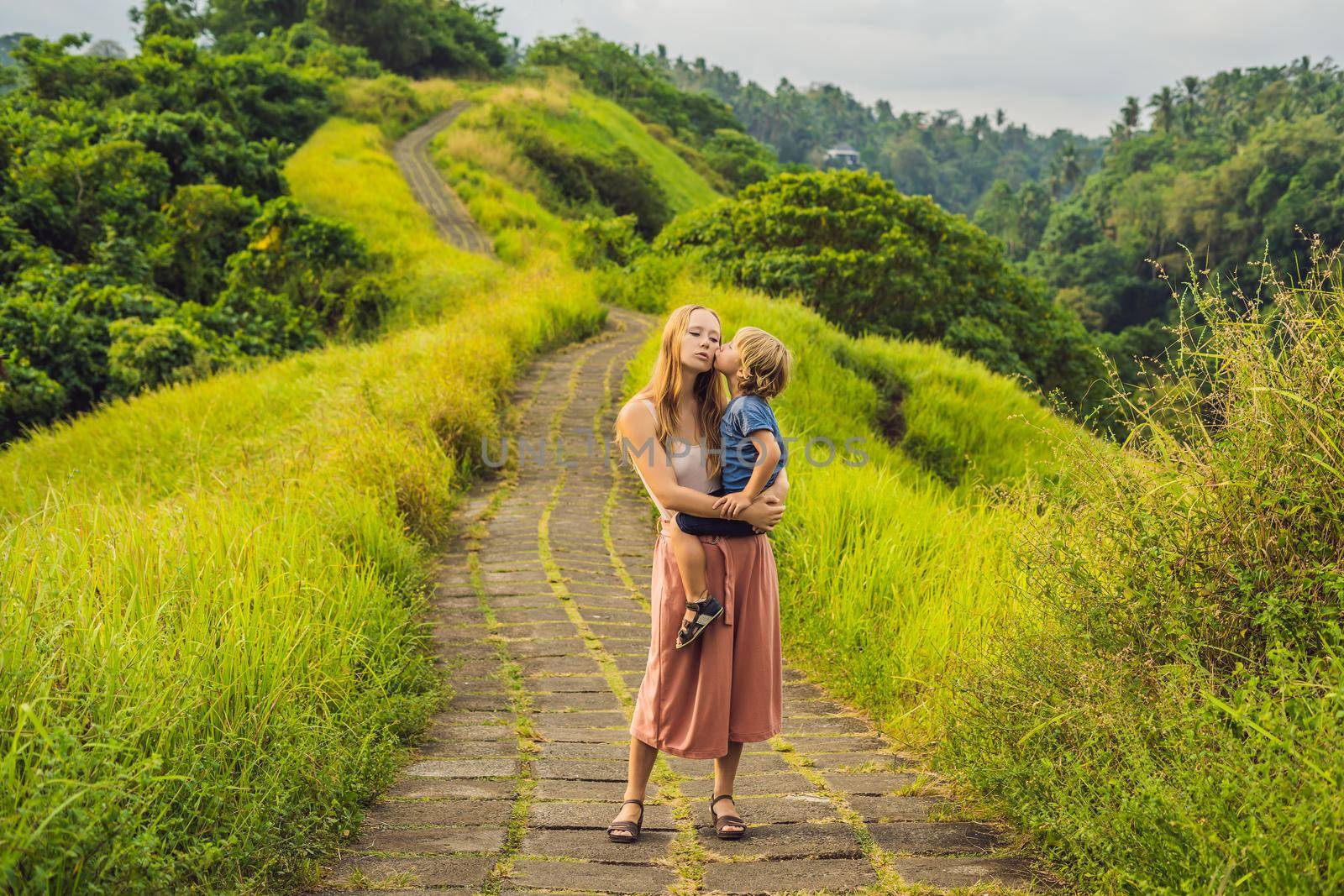 Mom and son tourists in Campuhan Ridge Walk , Scenic Green Valley in Ubud Bali. Traveling with children concept.