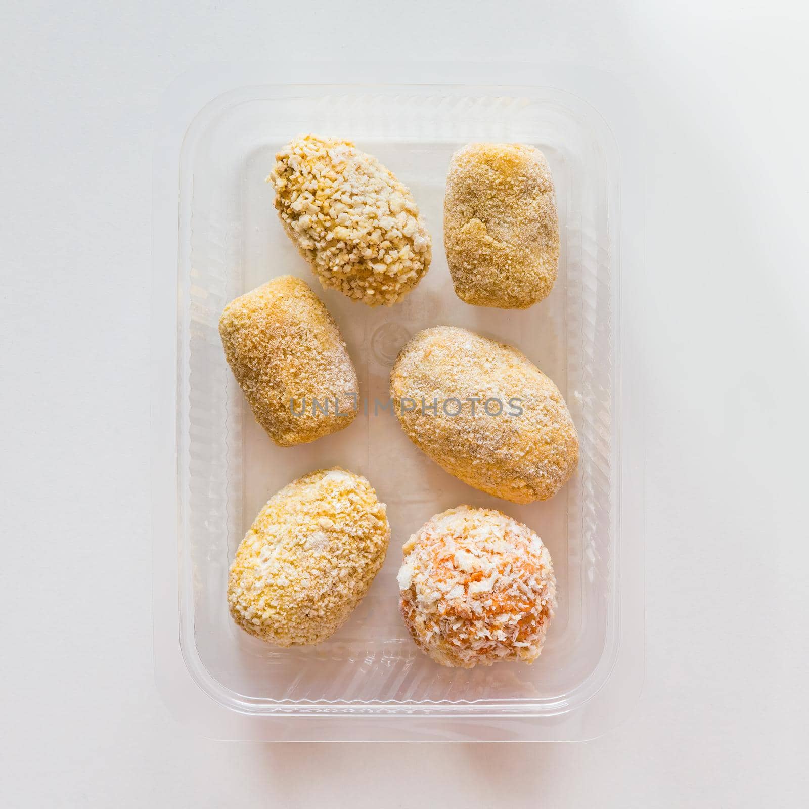 Assortment of raw frozen croquettes in transparent tray. Mediterranean and spanish cuisine. Preserved food for sale. by apavlin