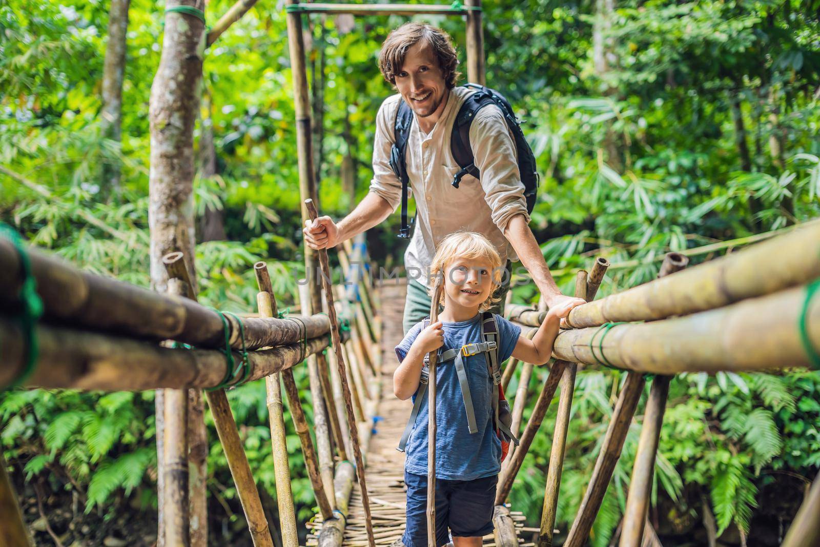 Father and son travelers on the suspension bridge in Bali. Traveling with children concept. by galitskaya