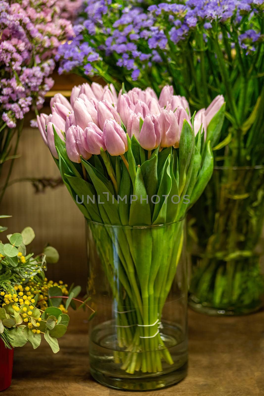 Pink tulips in flower shop with other flowers at the background. Bouquet of flowers for sale.
