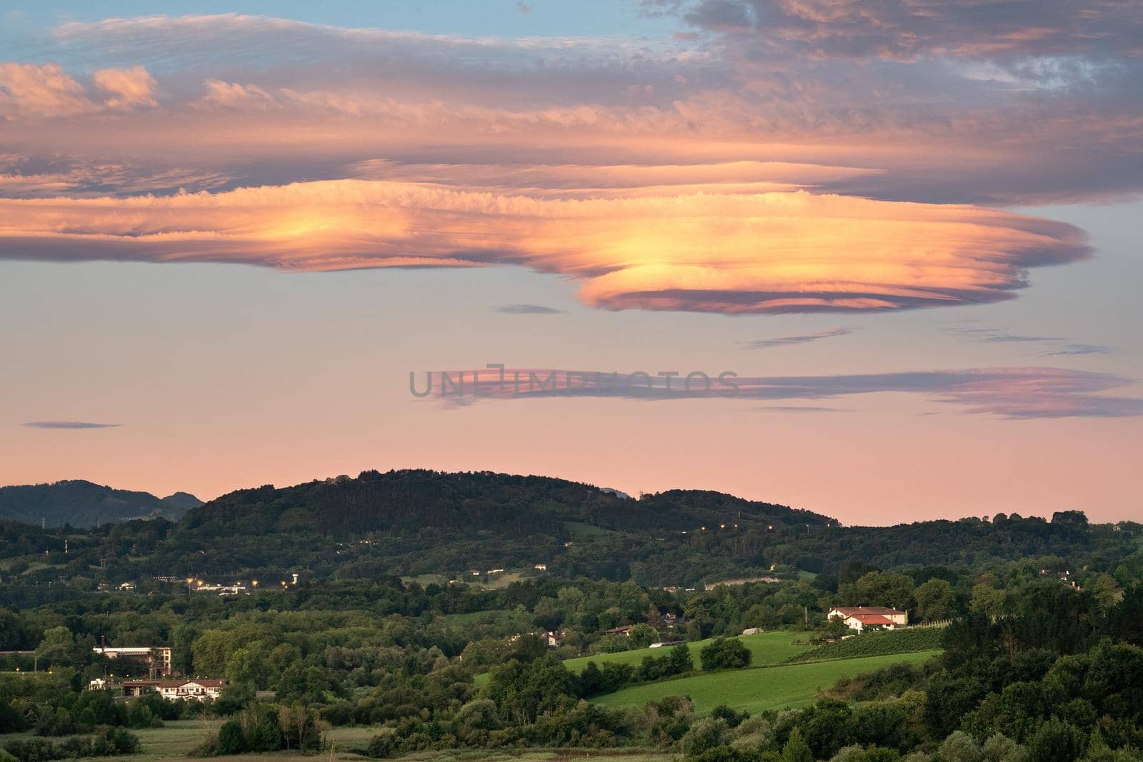 Amazing colorful lenticular clouds over village in countryside. Irun, Basque Country, Spain. Camino de Santiago