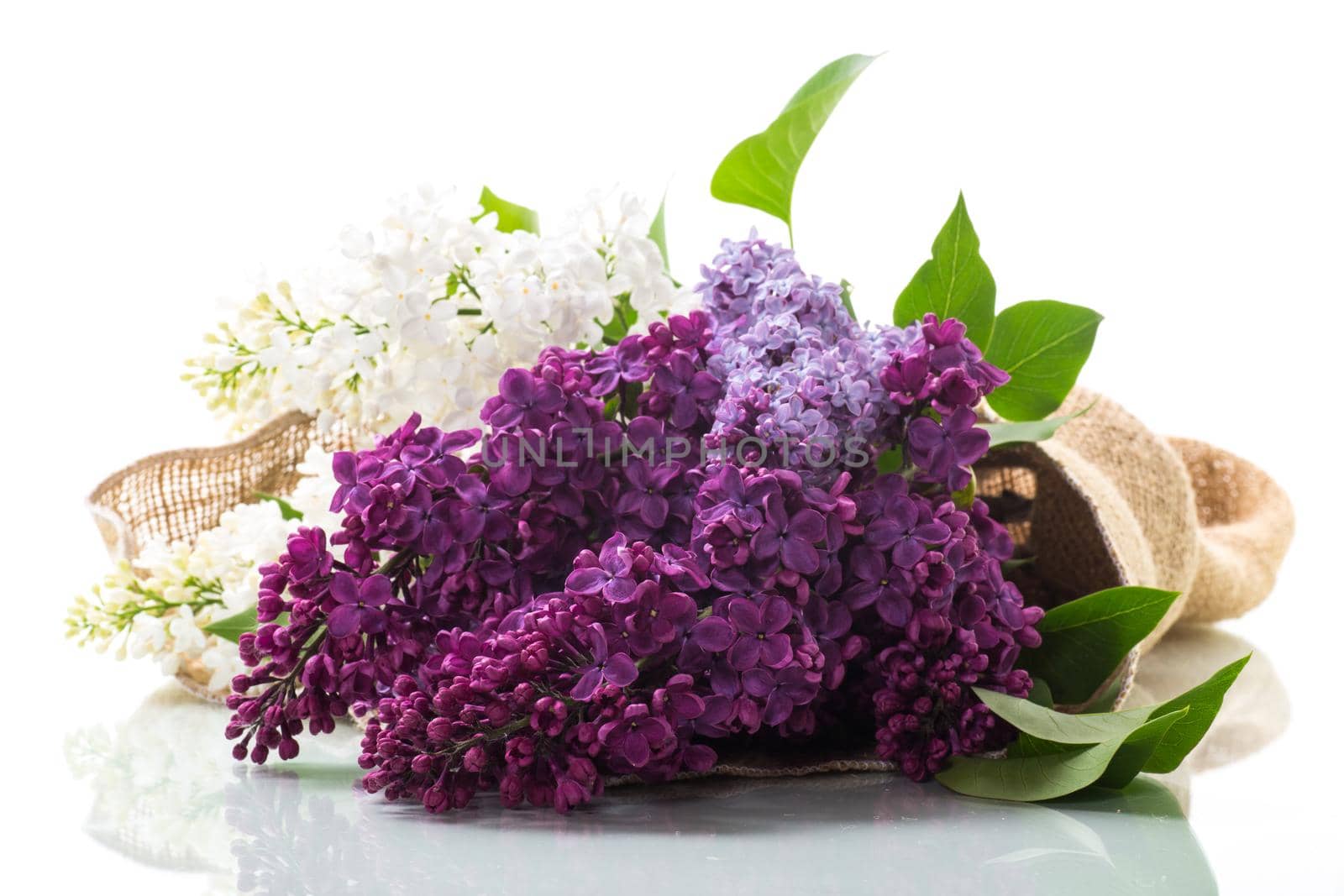 Bouquet of beautiful spring lilacs of different colors on a wooden table