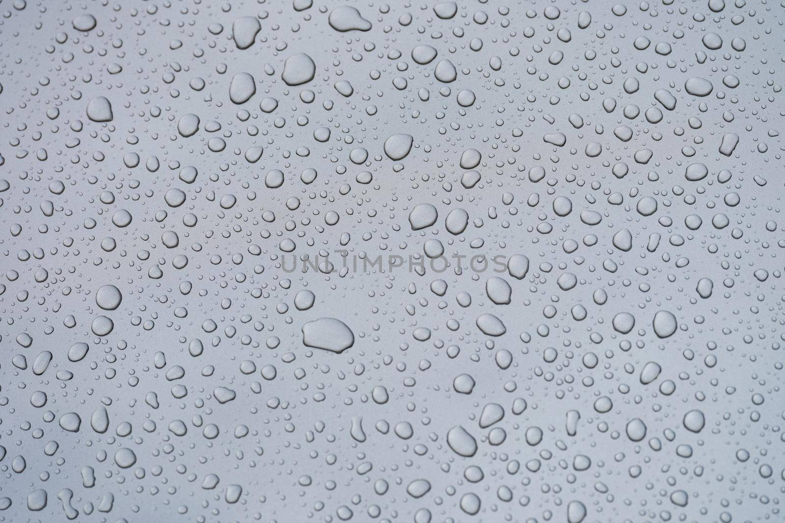 Closeup of raindrops on gray window glass texture background by kuprevich
