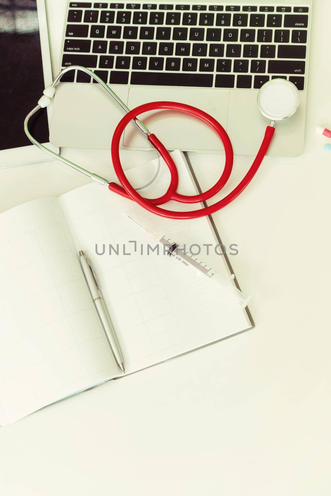 Medical healthcare backgrounds flat lay objects with copy space. Doctor stethoscope, medicine, laptop computer and notebook on white office table.