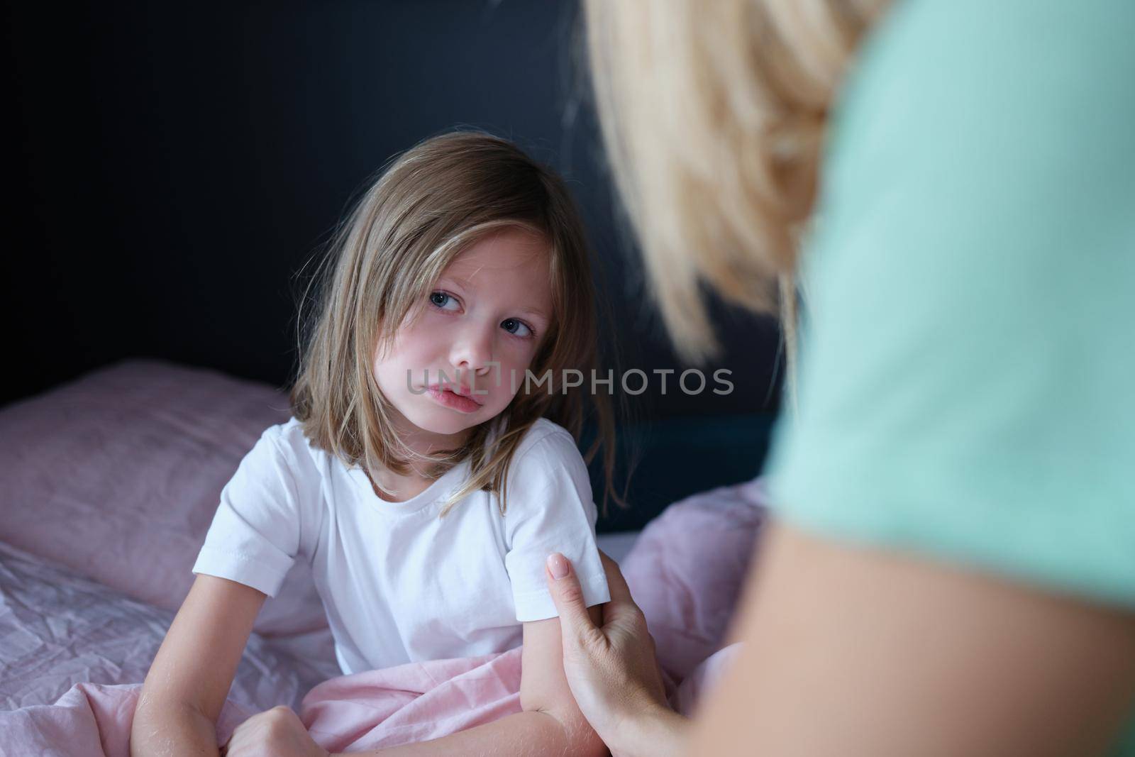 Upset sad little girl communicates with mom at home. Tactile contact of children and parents concept