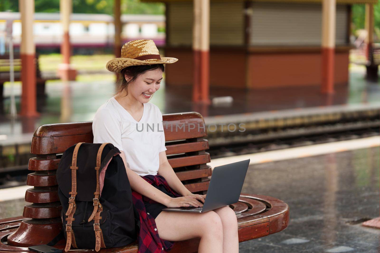 Image of Young freelance working at train station before travel. work and travel concept