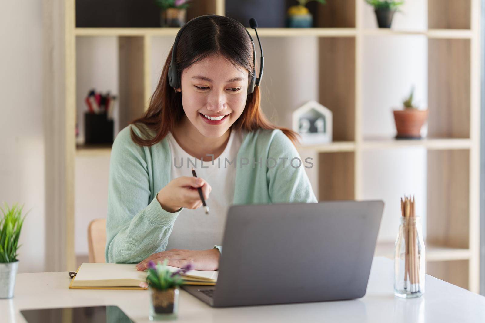 Smiling Asian attentive student studying online class. e-learning education concept