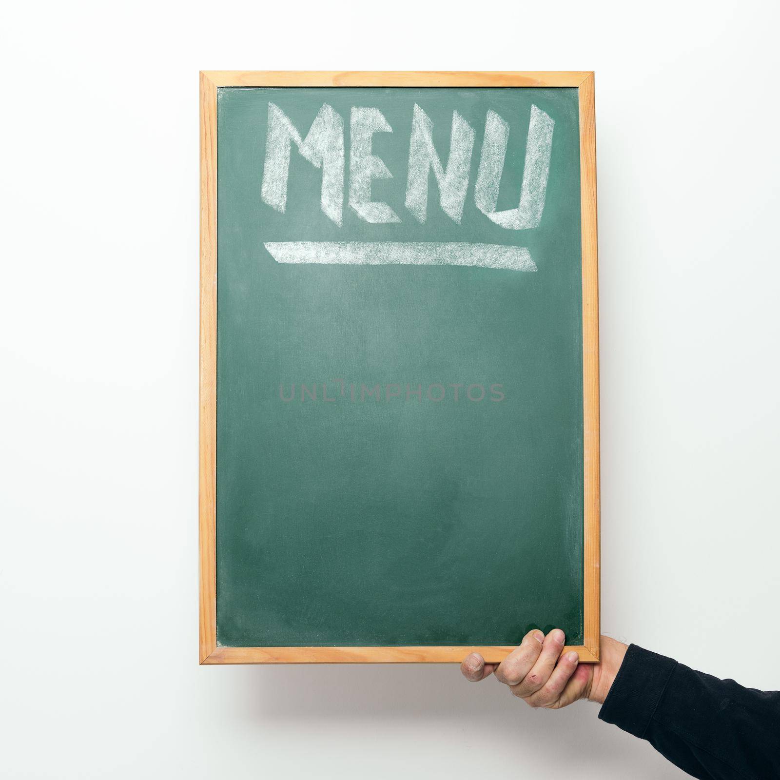 hand holding a chalkboard with the word MENU handwritten in chalk, copyspace for text
