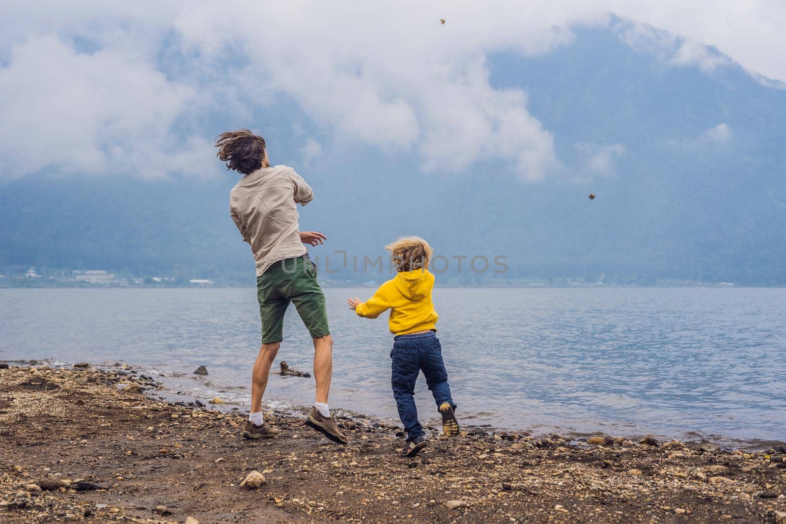 Father and son at the lake Bratan and the mountains covered with clouds by galitskaya