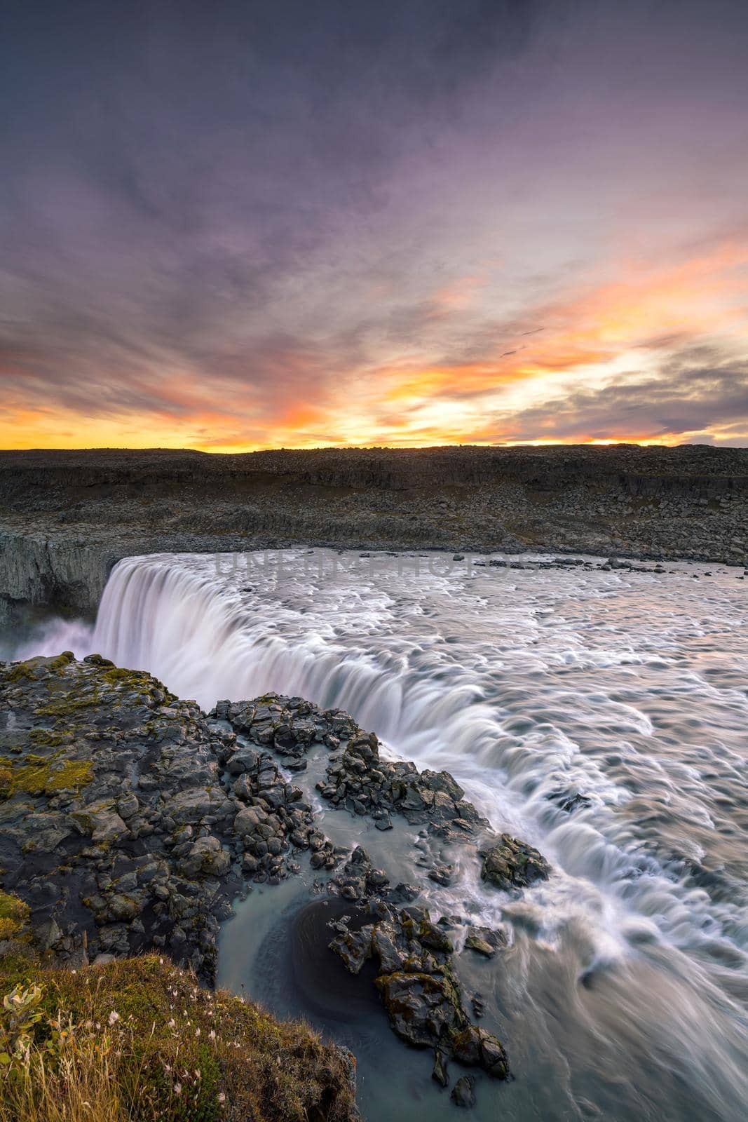 Detifoss waterfall with sunset in the background by f11photo