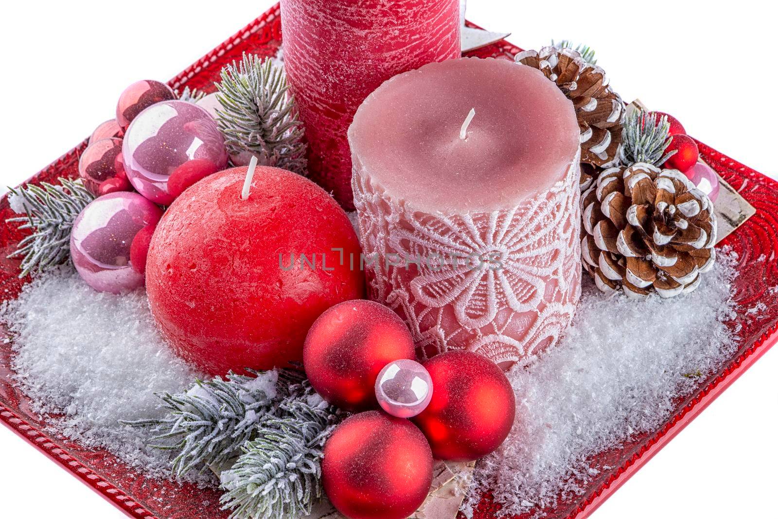 Holiday decoration with candles, cones and snow. Isolated on white