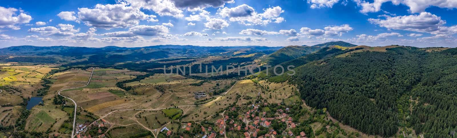 Amazing Aerial panorama from a drone of countryside fields, trees, a mountain peaks at cloudy day. Countryside. Stunning detailAmazing Aerial panorama from a drone of countryside fields, trees, a mountain peaks at cloudy day. Countryside. Stunning detail