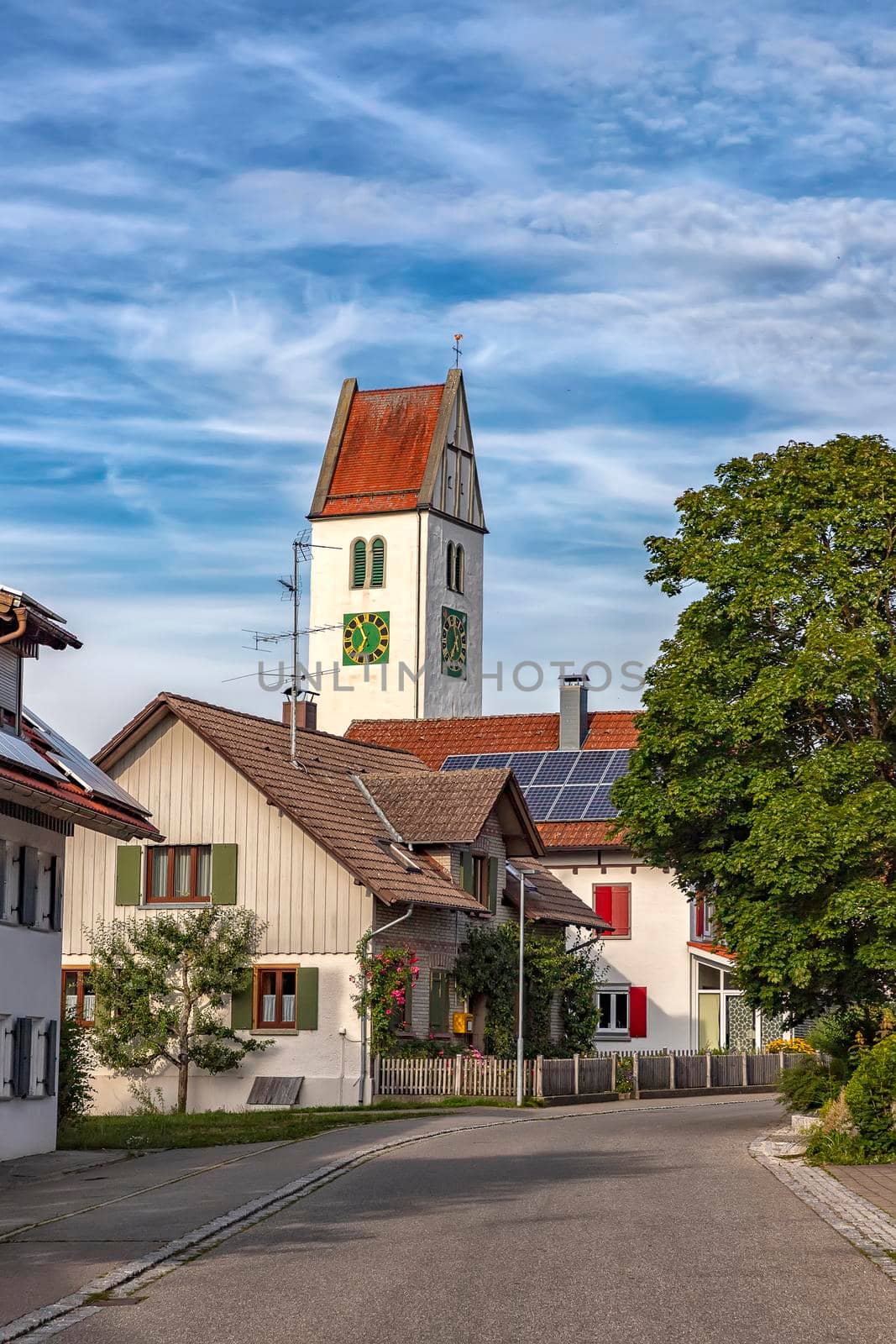 a small quiet street with houses and a clock tower in Leutkirch, Germany by EdVal