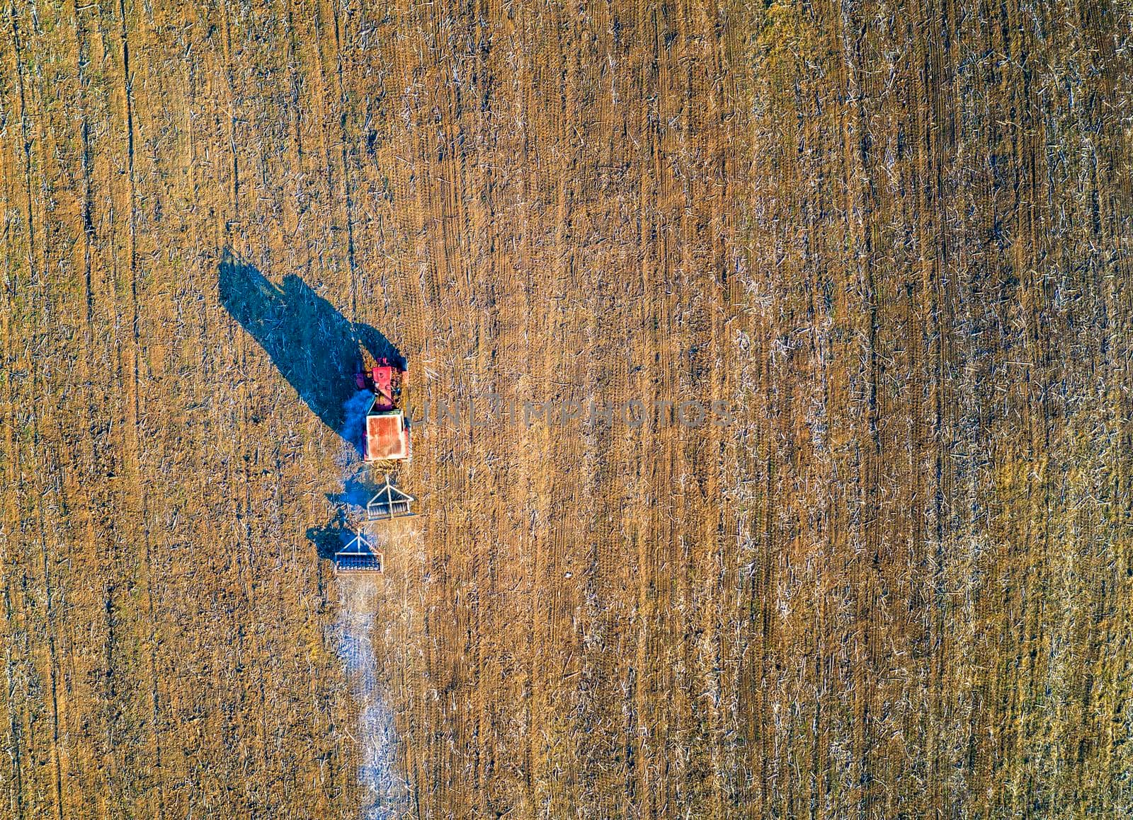 Aerial view from drone of field processing with the tractor. Agriculture processing of fields. Top view