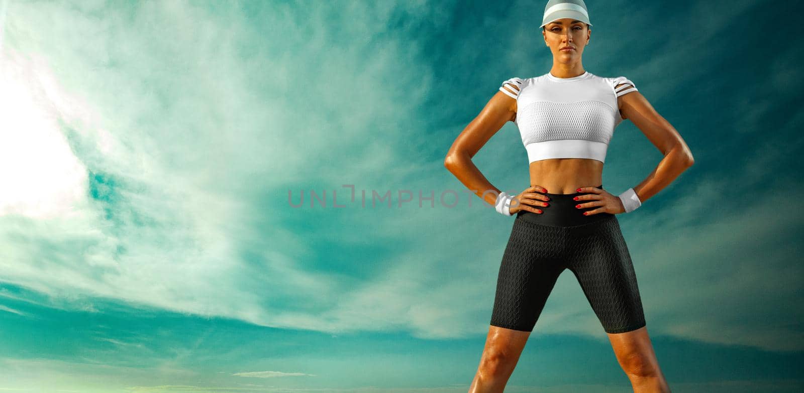 Sporty and fit young woman athlete relaxed after yoga training on the sky background. The concept of a healthy lifestyle and sport. Woman in black and white sportswear. by MikeOrlov