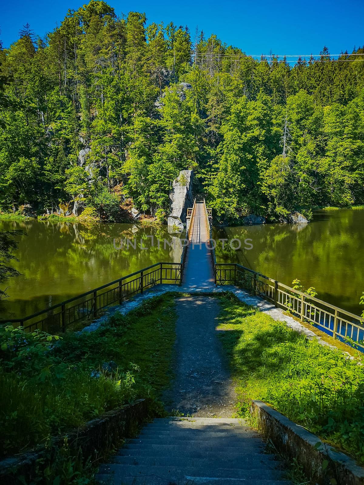 Long steel hanging footbridge over Modre lake by Wierzchu