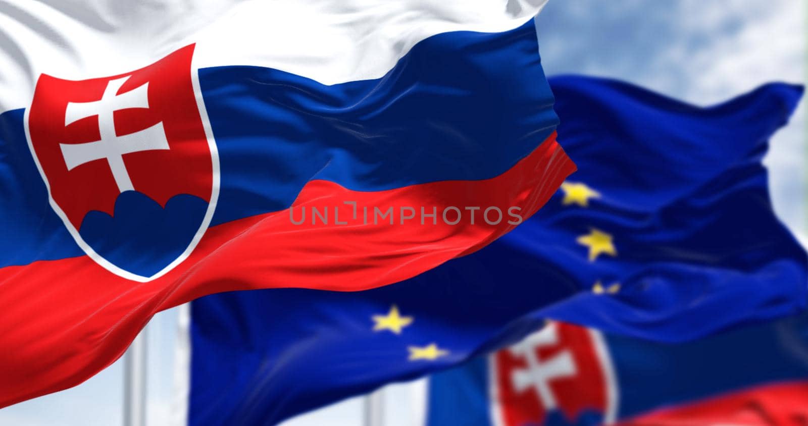 Detail of the national flag of Slovakia waving in the wind with blurred european union flag by rarrarorro