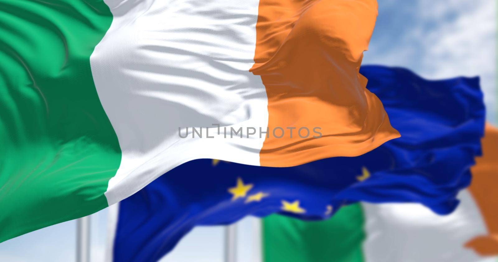 Detail of the national flag of Ireland waving in the wind with blurred european union flag by rarrarorro