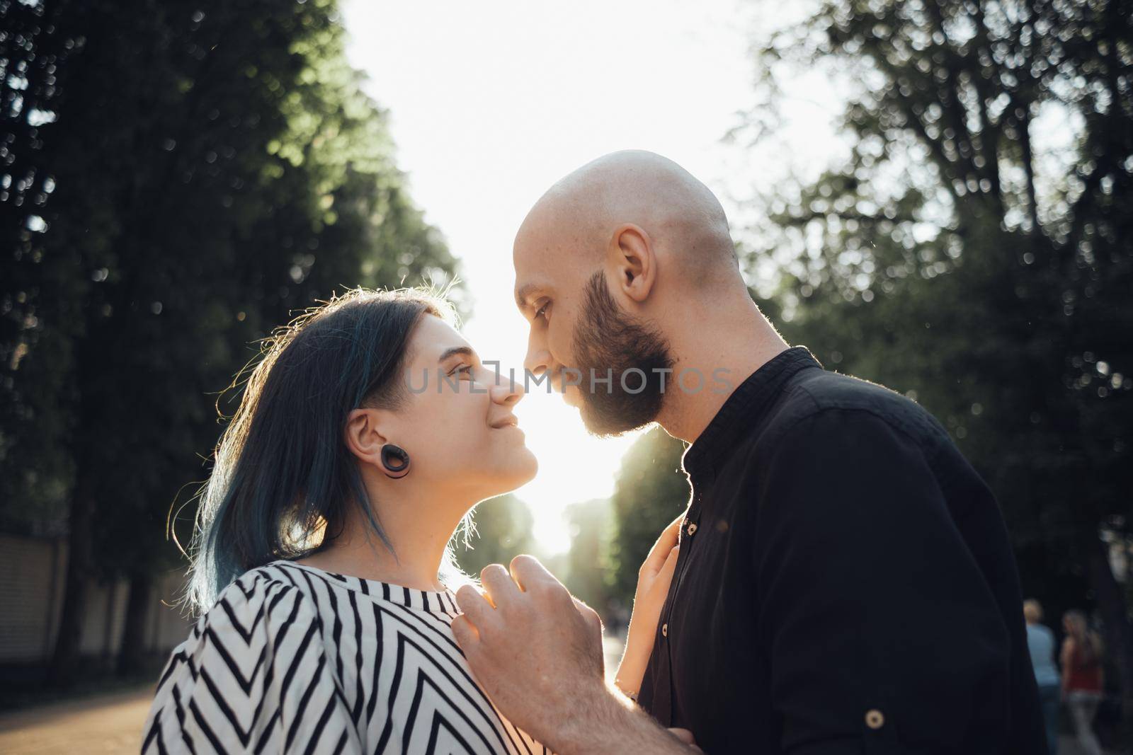 a loving couple hugs and looks into each other's eyes against the background of the summer sun. glare of the sun by Symonenko