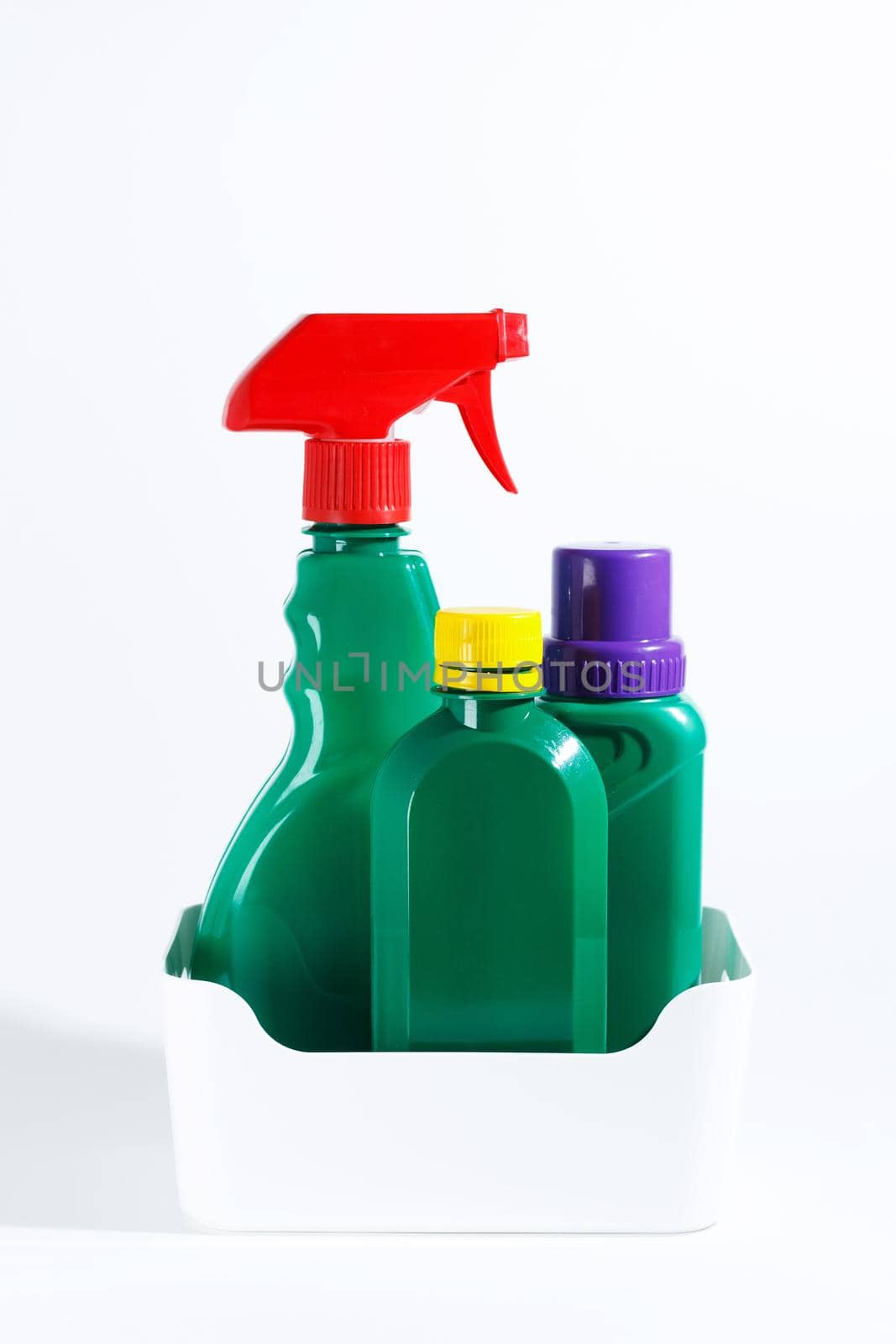 Bottles and spray of garden products and fertilizers for growing plants. Isolated on white background. vertical photo