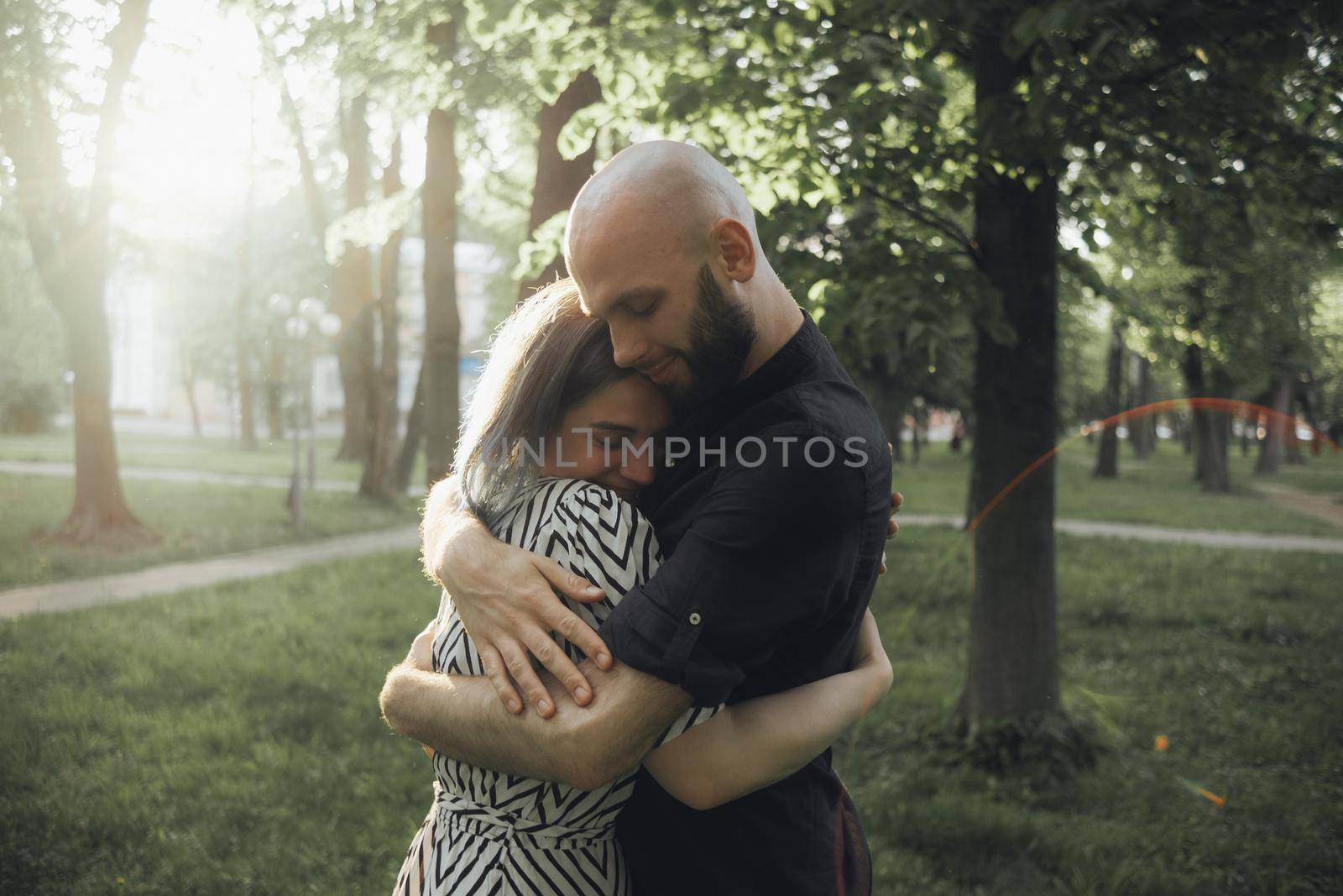 loved ones hug tightly in the summer sun in the park. glare of the sun. soft effect by Symonenko