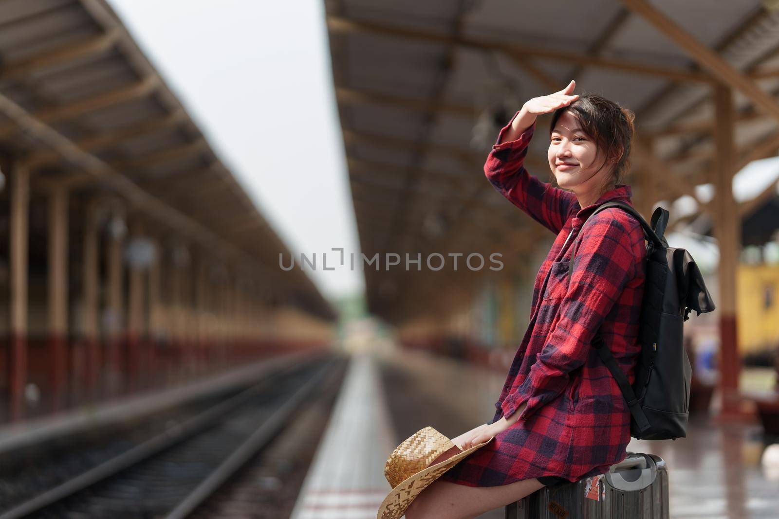 Young traveler woman planning trip at train station. Summer and travel lifestyle concept