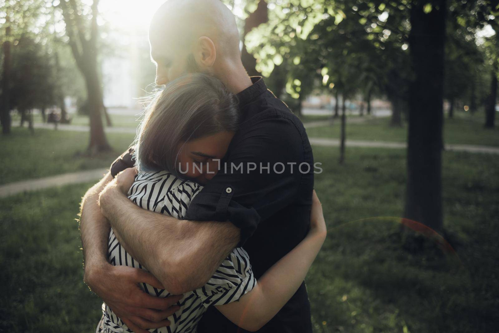 loved ones hug tightly in the summer sun in the park. glare of the sun. soft effect by Symonenko
